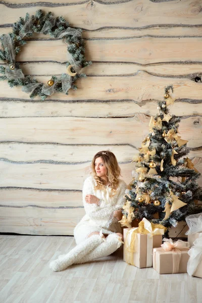 Девушка рядом с украшенной елкой в красивом светлом интерьере — стоковое фото