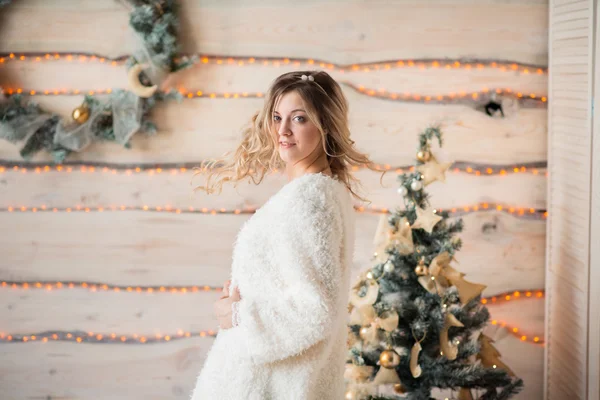 Chica cerca del árbol de Navidad decorado en el interior de la luz hermosa —  Fotos de Stock