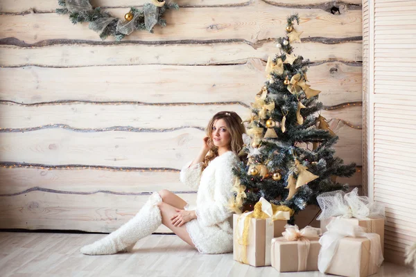 Vacker flicka i vit klänning sitter nära en vacker träd — Stockfoto