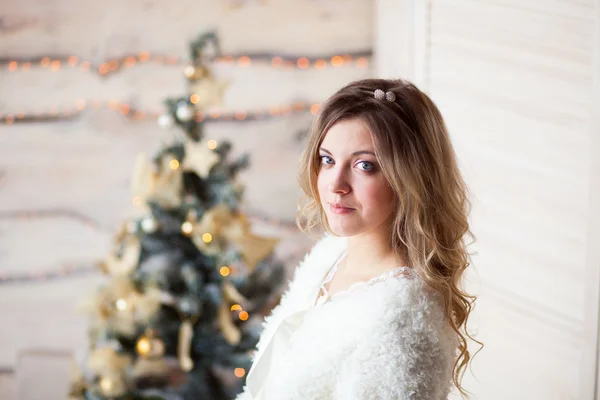 Beautiful girl in white dress sitting near a beautiful tree — Stock Photo, Image