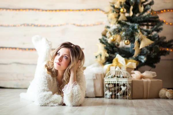 Bella ragazza in abito bianco seduta vicino a un bellissimo albero — Foto Stock