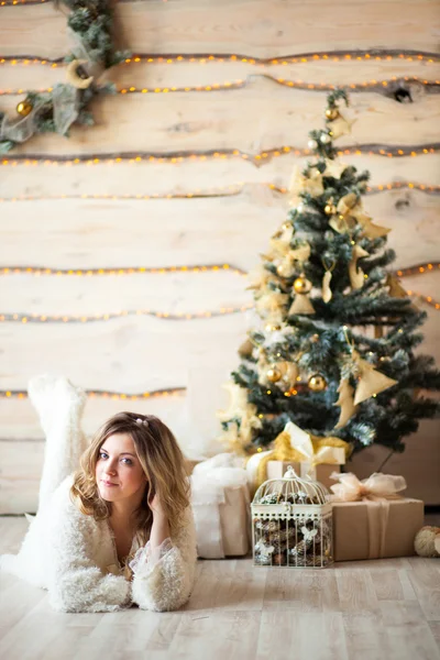 Girl near the decorated Christmas tree in beautiful light interior — Stock Photo, Image
