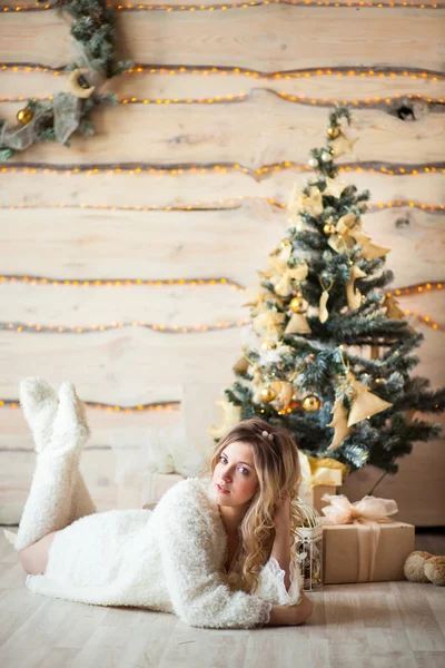 A szép lány a fehér ruha gyönyörű fa közelében ült — Stock Fotó