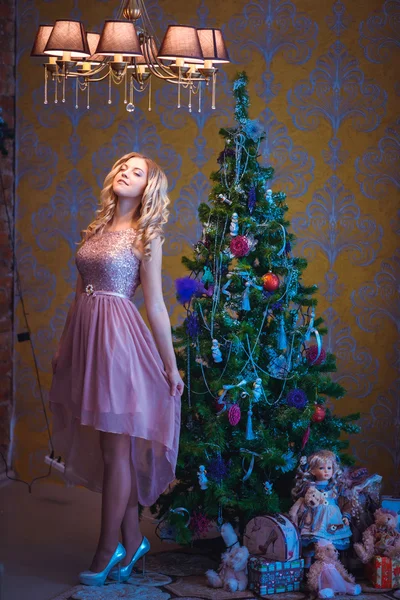 La fille assise à côté de l'arbre de Noël décoré — Photo