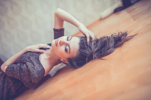 Seductive woman lying on the floor Stock Picture