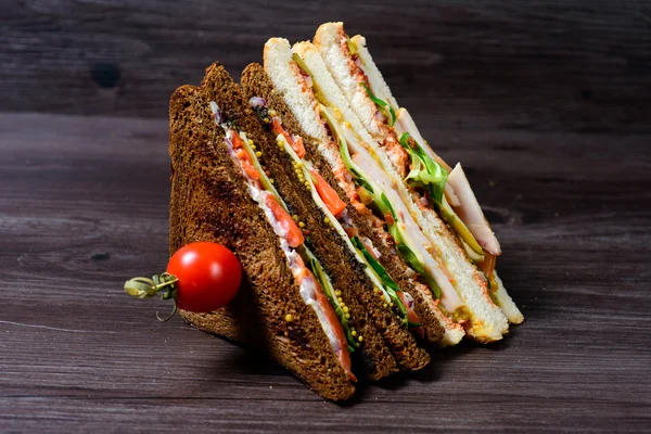 Clubsandwiches recém-preparados em uma tábua de corte de madeira — Fotografia de Stock