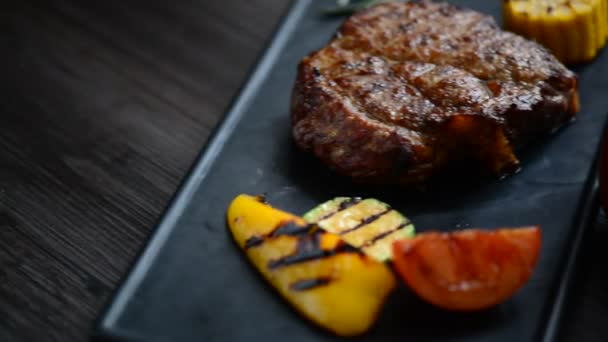 Bife de porco servido com molho vermelho e legumes — Vídeo de Stock