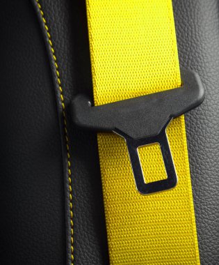 Modern yarış arabasının içi siyah deri. Sarı deri koltuğun bir parçası. Emniyet kemeri yakın plan.