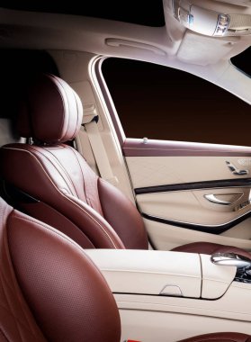 Modern lüks araba, direksiyon, vites kolu ve gösterge paneli. Araç içi lüks. Bej rahat koltuklar, direksiyon, gösterge paneli, hız göstergesi, ekran. Kırmızı ve beyaz delikli deri..