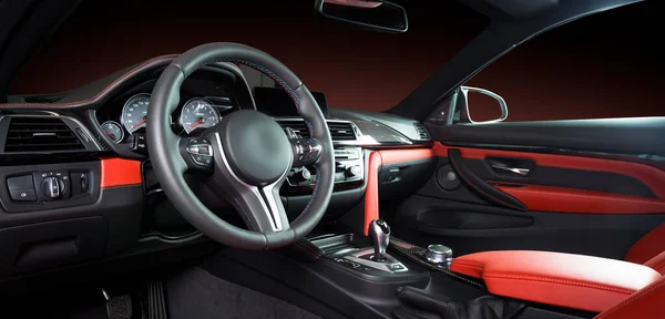 現代の高級車インテリア ステアリングホイール シフトレバーとダッシュボード 車の内装の豪華さの中 ステアリングホイールダッシュボードスピードメーターディスプレイ 赤と黒の革のコックピット — ストック写真