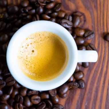 Ahşap desenli, ahşap arka planda yeni demlenmiş bir fincan espresso kahvenin genel manzarası. 