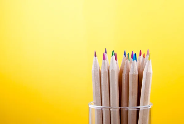 Crayons de bois colorés sur fond jaune — Photo