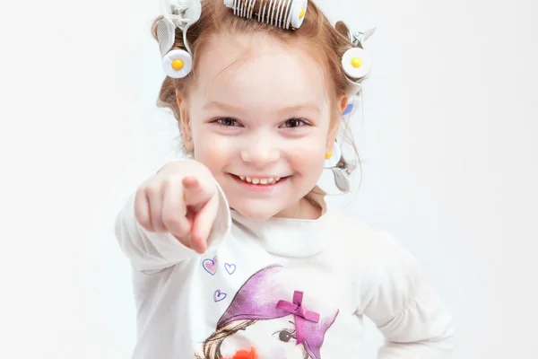 Bambina in bigodini per capelli su uno sfondo leggero Foto Stock Royalty Free