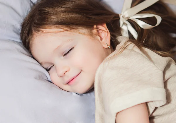 Kleines Mädchen im Bett beim Spielen — Stockfoto