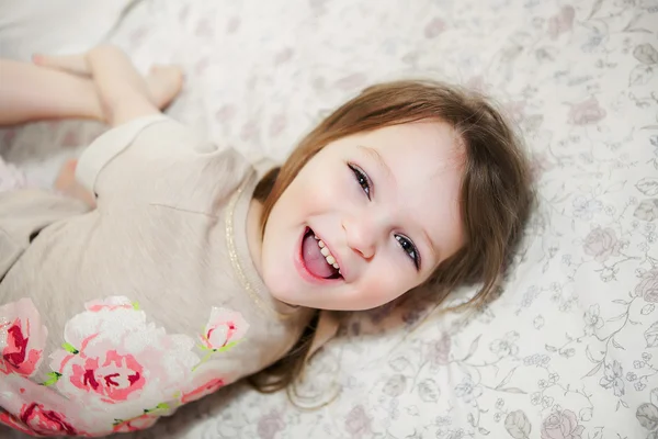 Kleines Mädchen im Bett beim Spielen — Stockfoto