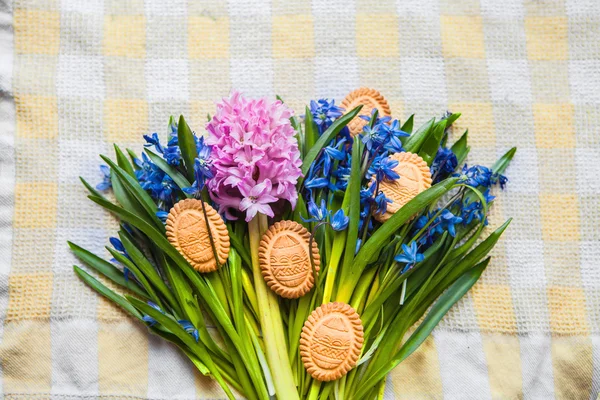 Vista dall'alto di biscotti nella forma di uova di Pasqua si trovano su colori scilla su asciugamano da cucina giallo Fotografia Stock