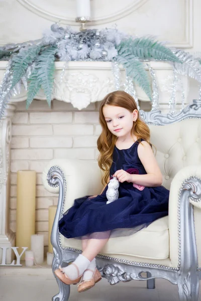 Niña en un vestido elegante sentada en una silla — Foto de Stock