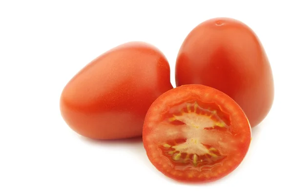 Fresh and colorful italian roma tomatoes and a cut one — Stock Photo, Image