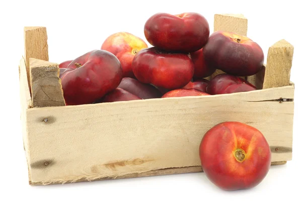 Fresh wild flat nectarines in a wooden crate — Stock Photo, Image