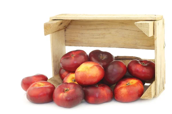 Nectarinas planas silvestres frescas en una caja de madera —  Fotos de Stock
