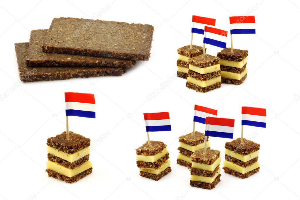 traditional layered rye bread and cheese snacks with Dutch  flag toothpick and some pieces of rye bread on a white background