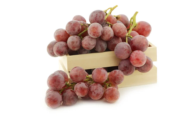 Свежий красный виноград на лозе в деревянном ящике — стоковое фото