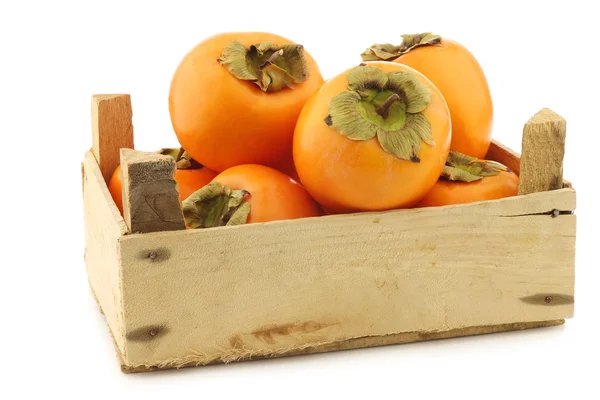 Fresh kaki fruit in a wooden crate — Stock Photo, Image