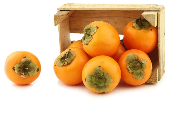 Fresh kaki fruit in a wooden crate — Stock Photo, Image