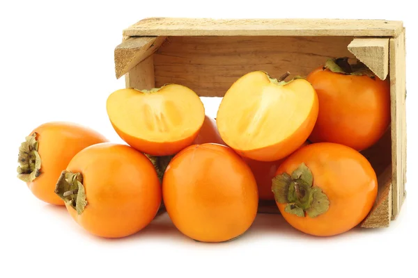 Fresh kaki fruit in a wooden crate — Stock Photo, Image