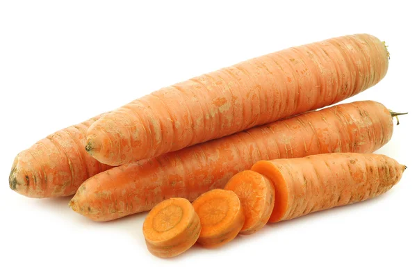 Three winter carrots and a cut one — Stock Photo, Image
