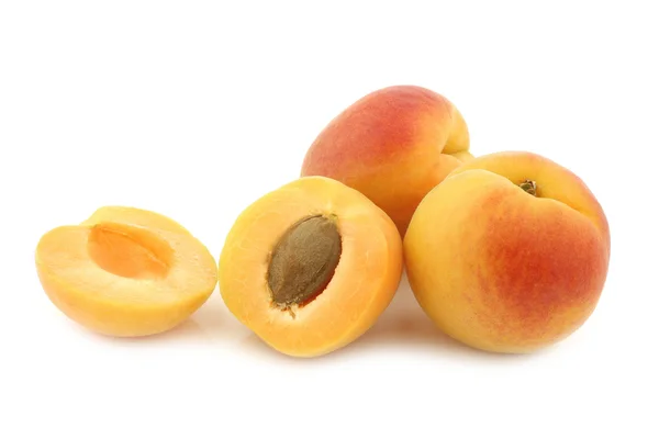 Fresh colorful apricots and a cut one — Stock Photo, Image