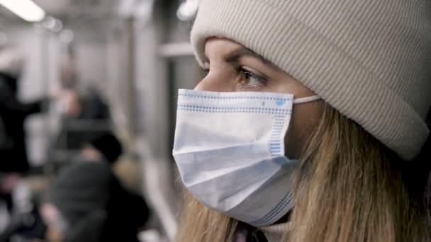 Kvinna bär en medicinsk mask på ansiktet resor i tunnelbanan bil kollektivtrafik — Stockvideo