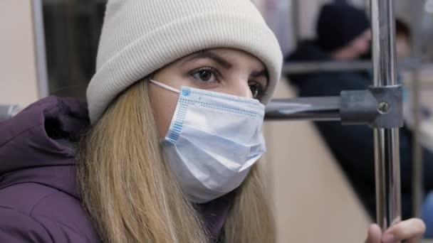 Kvinna bär en medicinsk mask på ansiktet går till tunnelbanan bil kollektivtrafik — Stockvideo
