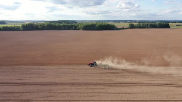 Le tracteur agricole nettoie le sol avant la plantation et plante les cultures au champ au printemps automne — Video