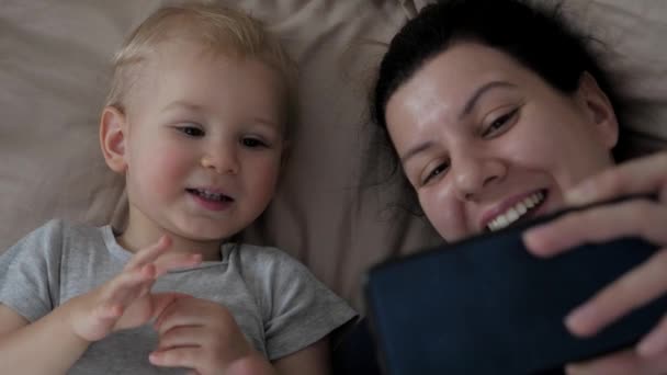 Anya és a gyereke videóhívást intéznek az apjukhoz vagy a családjukhoz. — Stock videók