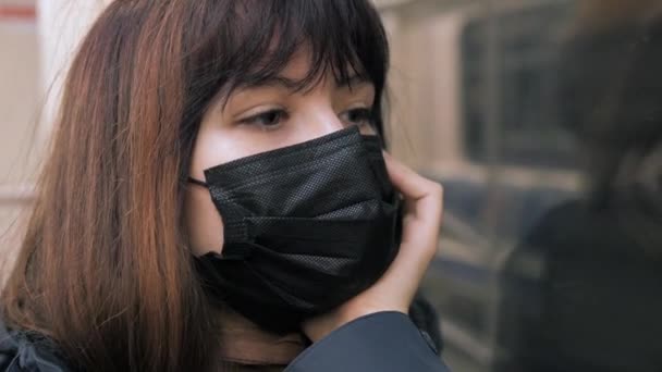 Virüs maskeli üzgün kadın metroya biniyor ve kederli bir şekilde pencereden dışarı bakıyor. — Stok video