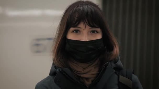 Porträtt av kvinna i mask tittar på kameran mot ett rörligt fordon transport — Stockvideo