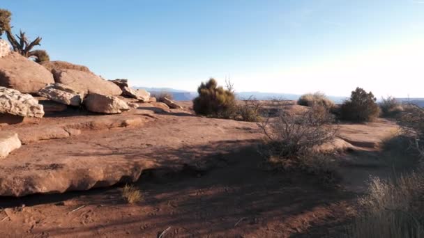 Pohyb letecké kamery v zaschlé písečné červené kamenné poušti s keři a háčky — Stock video