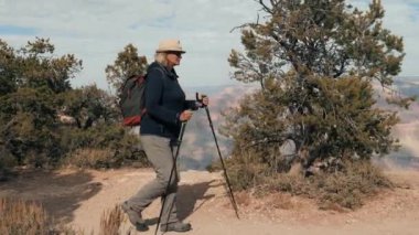 Sırt çantalı yaşlı kadın Büyük Kanyon Parkı 'nın dağlarında yürüyüş yapıyor.