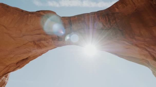 Soleil brille à travers une voûte rocheuse d'orange ardent coloré dans le parc national des Arches — Video