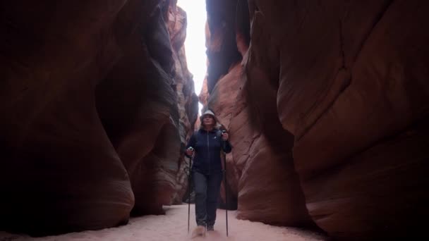 Πεζοπόρος που περπατά σε ξηρή καμπύλη Ποταμός σε βαθιά Slot Canyon με κόκκινο Smooth Rocks — Αρχείο Βίντεο