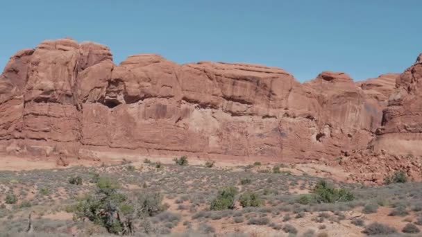 Formación de acantilados masivos de naranja roja en Arches Park en un día soleado en movimiento — Vídeos de Stock