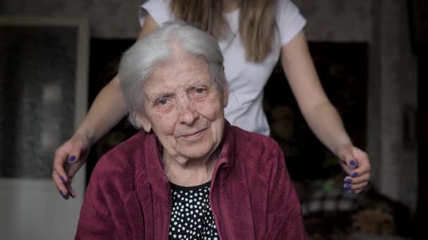Eine Frau mit einem Lächeln umarmt ihr altes Großmutterporträt — Stockvideo