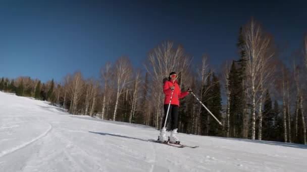 Elegancka kobieta na nartach w dół stoku ku słońcu w zimie w górach Resort — Wideo stockowe