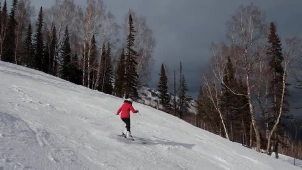 Sciatore sportivo Sciare sulla pista da sci in montagna nella giornata soleggiata d'inverno in movimento — Video Stock