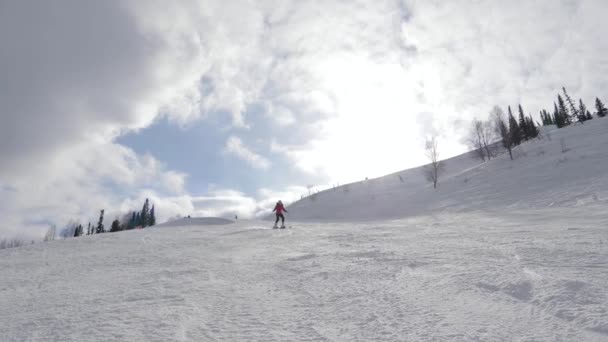 Esquiador de montaña esquiando en pista nevada en la estación en el día soleado en invierno — Vídeo de stock