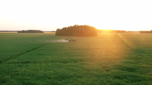 Aerial Follow Farm Tractor Sprays Mineral Water On Agricultural Field At Sunset — Stock Video