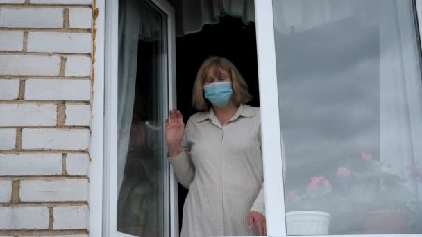 Woman In Medical Mask On Face Opens Window And Looks Out Breathing Fresh Air — ストック動画