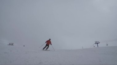 Profesyonel Alp kayakçısı kışın dağlarda dik kayak yapıyor.