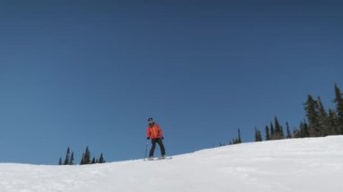 Güneşli bir günde dağlarda kayak yaparken mutlu kayakçılar.